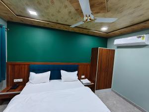 a bedroom with a large bed with a green wall at Hotel Ajmer Pride in Ajmer