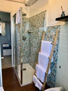 a bathroom with a shower and towels on a wall at A due passi dalla Certosa in Certosa di Pavia +17 photos