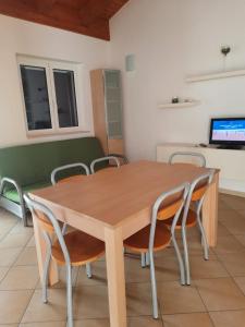a dining room with a wooden table and chairs at Dimora sul mare in Policoro +3 photos