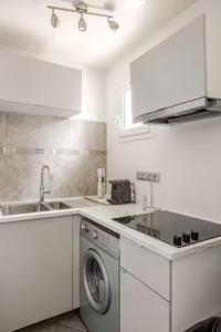 a kitchen with a washing machine and a sink at Charme et confort in Valenton