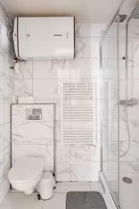 a white bathroom with a toilet and a shower at Charme et confort in Valenton