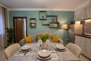 a dining room table with a vase of flowers on it at Smart Apartments Central in Sighişoara