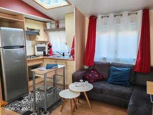 a living room with a couch and a kitchen at Mobil home au bord du lac de Foix in Foix