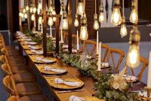 a long table with candles and plates of food at West East Suites in Imerovigli +122 photos