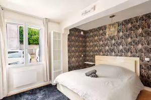 a bedroom with a large white bed and a window at Charme et confort in Valenton