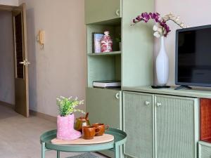 a living room with a table and a vase with flowers at Apartamento Cimadevilla Plaza in Oviedo