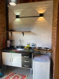 a small kitchen with a sink and a counter at Chalés Roma in Santo Antônio do Pinhal