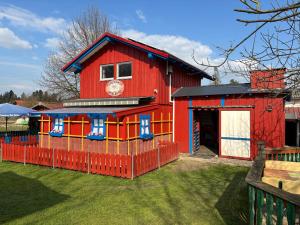 a red house with a fence in front of it at Ferienhaus Spielburg in Altötting