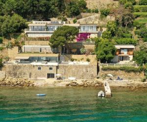 a group of houses on a hill next to the water at Seaside Resort in Santa Croce Mare