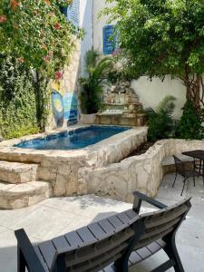 a swimming pool in a patio with a bench at Caribo Cozumel in Cozumel