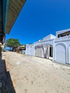 a white building sitting on top of a dirt road at YouYouKe Pavillon Karangpapak in Cilauteureun