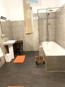 a bathroom with a tub and a sink and a shower at Malwatte Bungalows in Hali Ela +12 photos