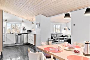a kitchen and living room with a table and chairs at 362-Hvide-Sande-Fyrmarken-35 in Hvide Sande