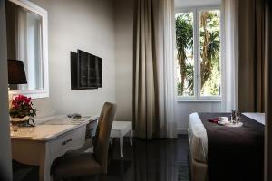 a hotel room with a desk and a bed and a window at Villa San Martino in Naples +28 photos