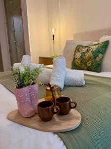 a tray with two cups on a bed at Apartamento Cimadevilla Plaza in Oviedo