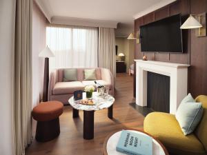 a living room with a couch and a table with a fireplace at The Green in Dublin