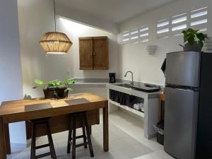 a kitchen with a table and a stainless steel refrigerator at Caribo Cozumel in Cozumel