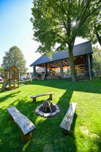 a park with benches and a fire pit in the grass at Apartamenty Tilia Laskowa - Zator in Laskowa