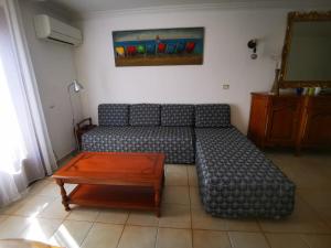 a living room with a couch and a table at Maison classée 3étoiles proche plage in Mauguio