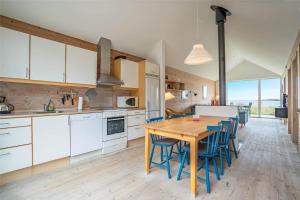 a kitchen with a wooden table and blue chairs at 702-Hvide-Sande-Slusen-2 in Hvide Sande