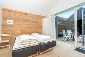 a bedroom with two beds and a balcony at 702-Hvide-Sande-Slusen-2 in Hvide Sande