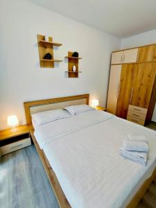 a bedroom with a large white bed with two towels on it at FLH - Apartament Central Silva in Sibiu