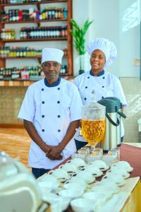 two chefs standing next to a table with food at Sumni Hotel in Nkoanrua
