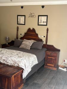 a bedroom with a large bed with a wooden headboard at Cloete Self Catering Sky Room in Ermelo
