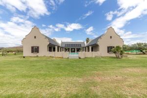 a large white house with a large yard at Millstream manor guest house in Robertson