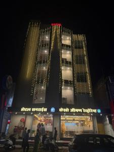 a tall building with lights on it at night at Hotel Sunrise in Damoh