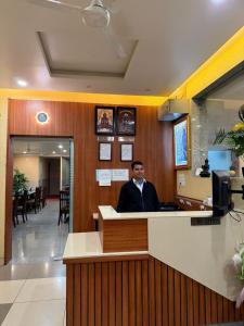 a man sitting at a counter in a restaurant at Hotel Sunrise in Damoh