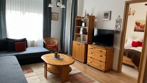 a small living room with a bed and a television at KŐNIG APARTMAN III. in Hévíz