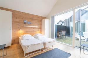 a bedroom with two beds and a large window at 712-Hvide-Sande-Slusen-12 in Hvide Sande