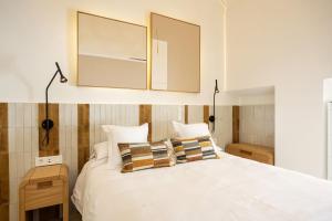 ein Schlafzimmer mit einem weißen Bett und zwei Kissen in der Unterkunft Aristoy - by Grupo Tribu in Tarifa