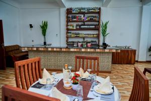 a dining room with a table and chairs and a bar at Sumni Hotel in Nkoanrua