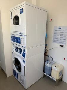 a washer and dryer stacked on top of each other at Moderno Centro Excelente CA1406 in Maringá +5 photos