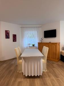 a dining room with a white table and chairs at Ferienapartment Lidia in Kastellaun