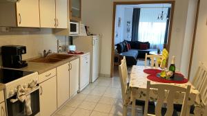 a kitchen with a table with a bottle of wine on it at KŐNIG APARTMAN III. in Hévíz +13 photos