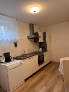 a kitchen with white cabinets and a stove top oven at Ferienapartment Lidia in Kastellaun