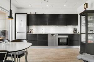 a kitchen with black cabinets and a table with chairs at 9928-Hvide-Sande-Langsand-86 in Hvide Sande +32 photos
