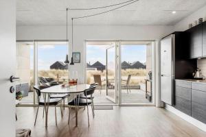 a kitchen and dining room with a table and chairs at 9928-Hvide-Sande-Langsand-86 in Hvide Sande