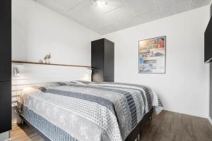 a bedroom with a bed with a blue and white blanket at 9928-Hvide-Sande-Langsand-86 in Hvide Sande