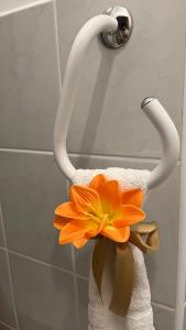 a towel holder with a orange flower in it at KŐNIG APARTMAN III. in Hévíz