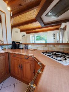 a kitchen with wooden cabinets and a stove top oven at Maison proche plage et commodités in Meschers-sur-Gironde