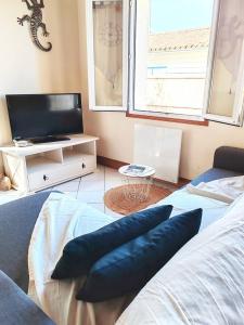 a living room with a bed and a tv at Maison proche plage et commodités in Meschers-sur-Gironde