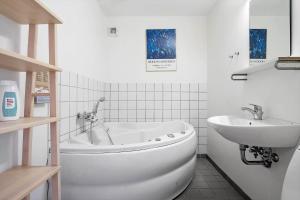 a white bathroom with a tub and a sink at 718-Hvide-Sande-Slusen-18 in Hvide Sande +26 photos
