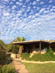 a house with a cloudy sky in front of it at Le case di Stella Maris in Palau