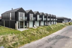 a row of black houses on a hill with a road at 718-Hvide-Sande-Slusen-18 in Hvide Sande