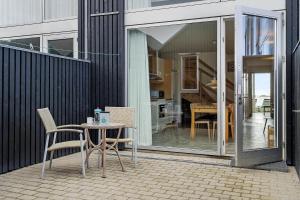 a patio with a table and chairs next to a building at 718-Hvide-Sande-Slusen-18 in Hvide Sande