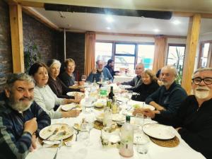 a group of people sitting at a table eating at Akainij in Puerto Williams